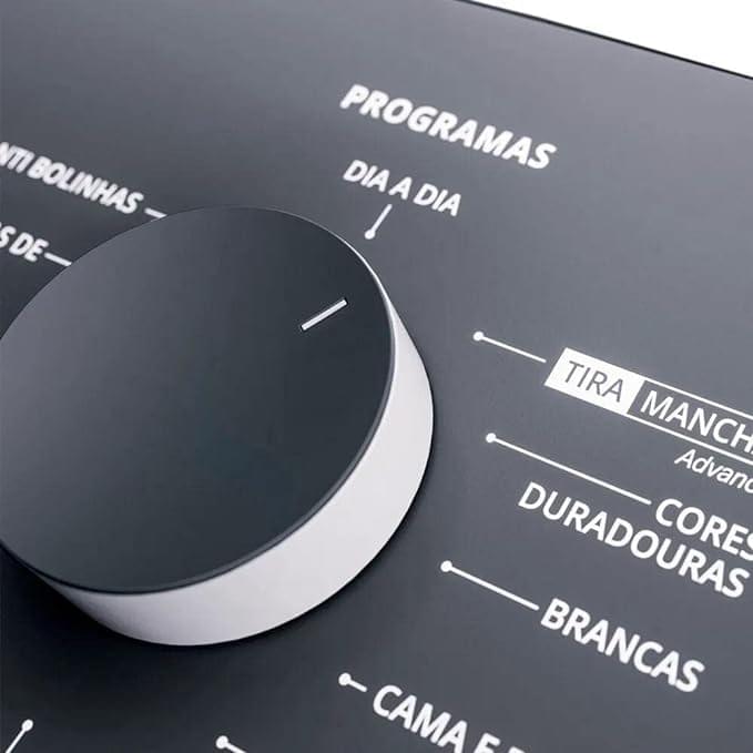 Foto do painel cinza da lavadora branca Brastemp BWK12, com abertura vertical (superior), e parte superior cinza, com os seus 12 programas de lavagem.